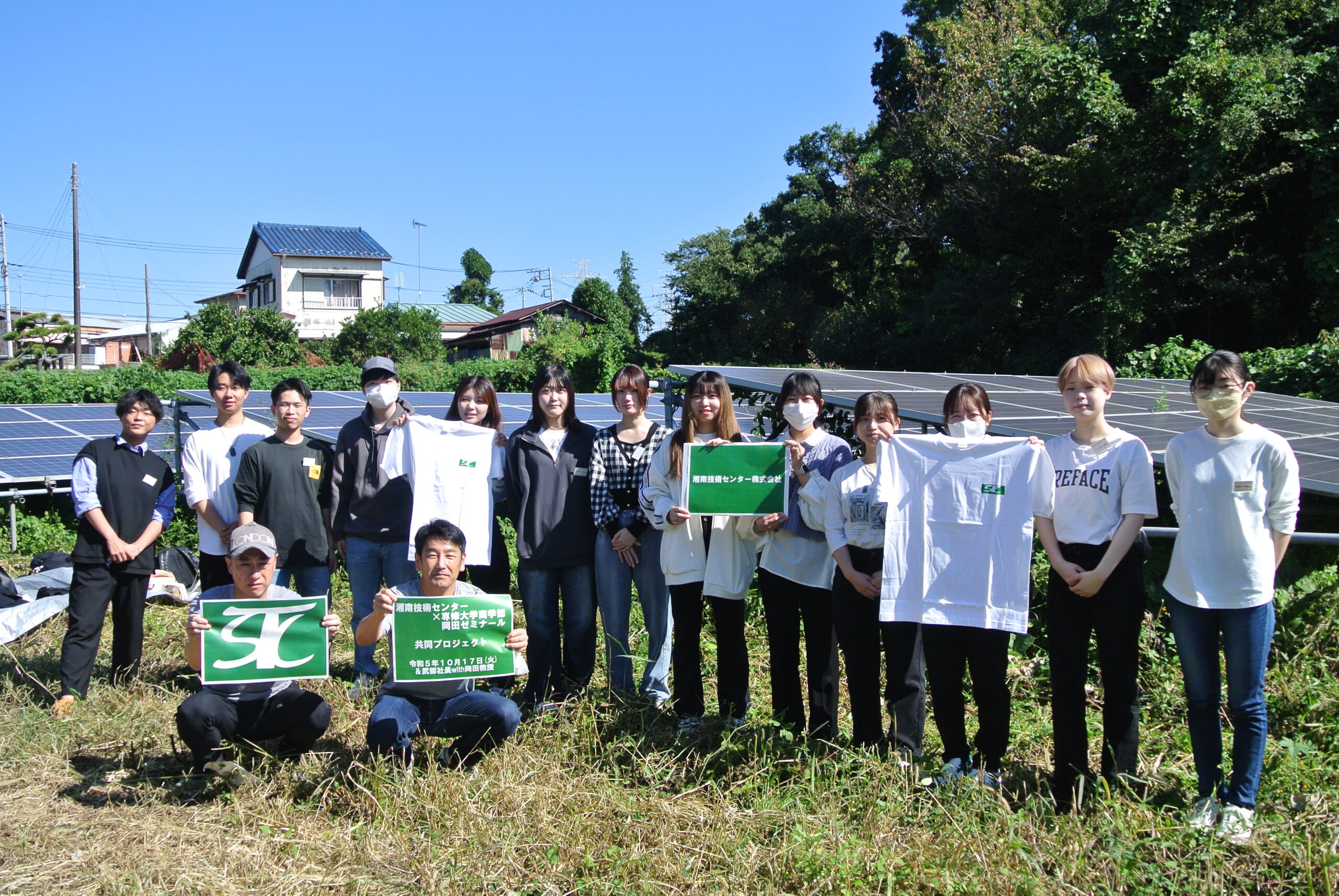 専修大学の学生さんと太陽光パネルの前で撮影した集合写真